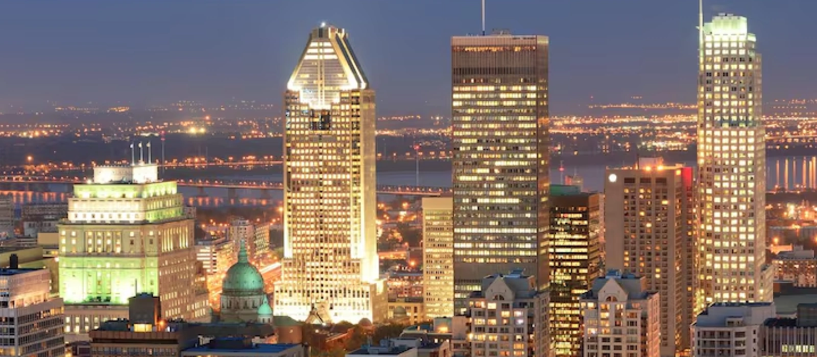 Montreal skyline illuminated at night with city skyscrapers and St Lawrence River
