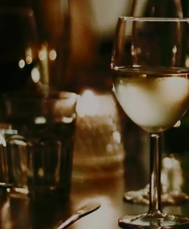 Close-up of wine glass on a candlelit table