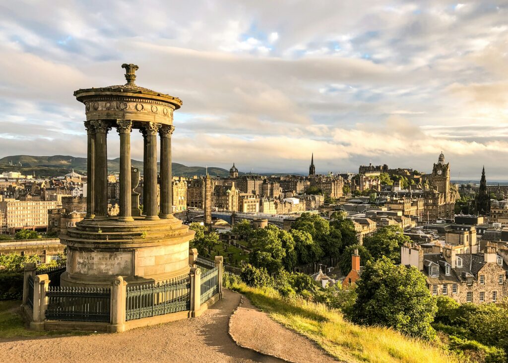 Panoramic historic cityscape view of Edinburgh Old Town and castle hill in Scotland.