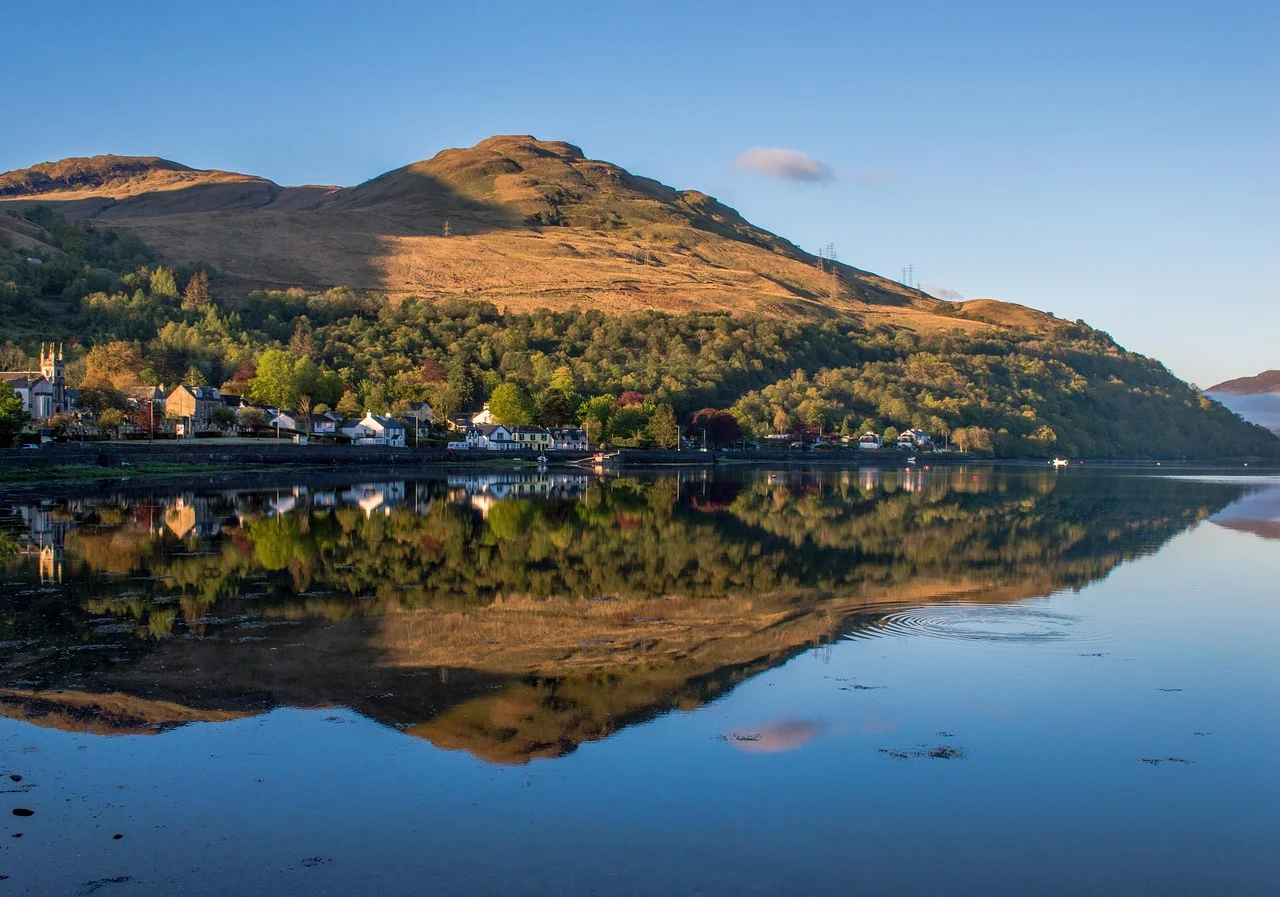 Loch Lomond and Conic Hill reflected in calm water in Scotland