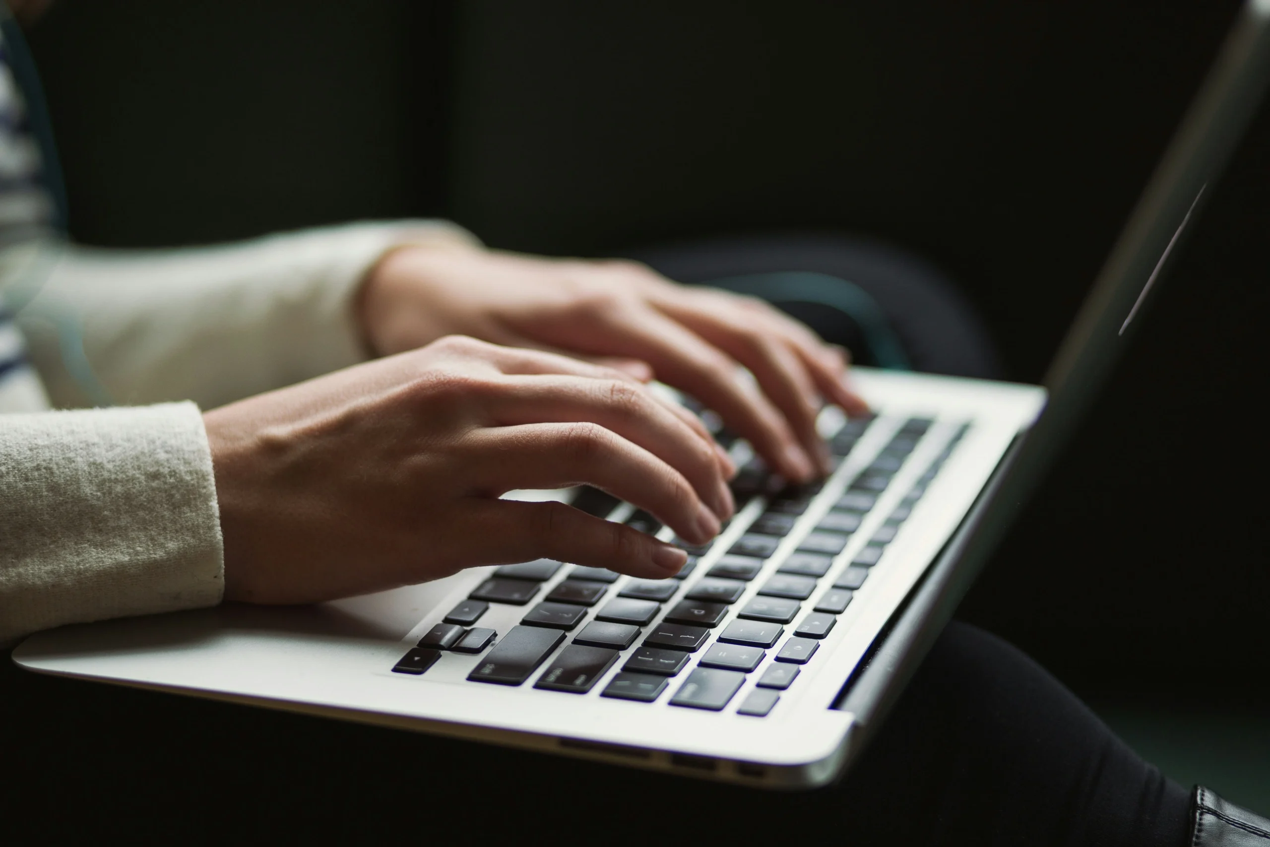 Close-up of hands typing on a laptop keyboard, representing productivity and digital work.