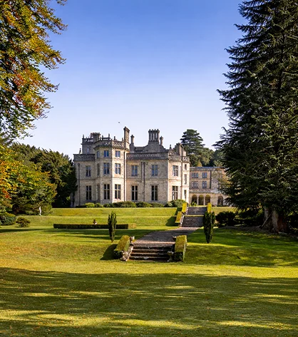 A stunning Welsh countryside with misty mountains, rolling hills, and vibrant fields.