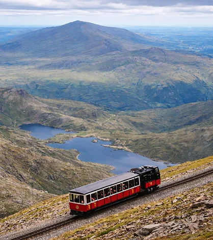 Panoramic view of Wales’ countryside with rolling hills and clear skies stretching afar.