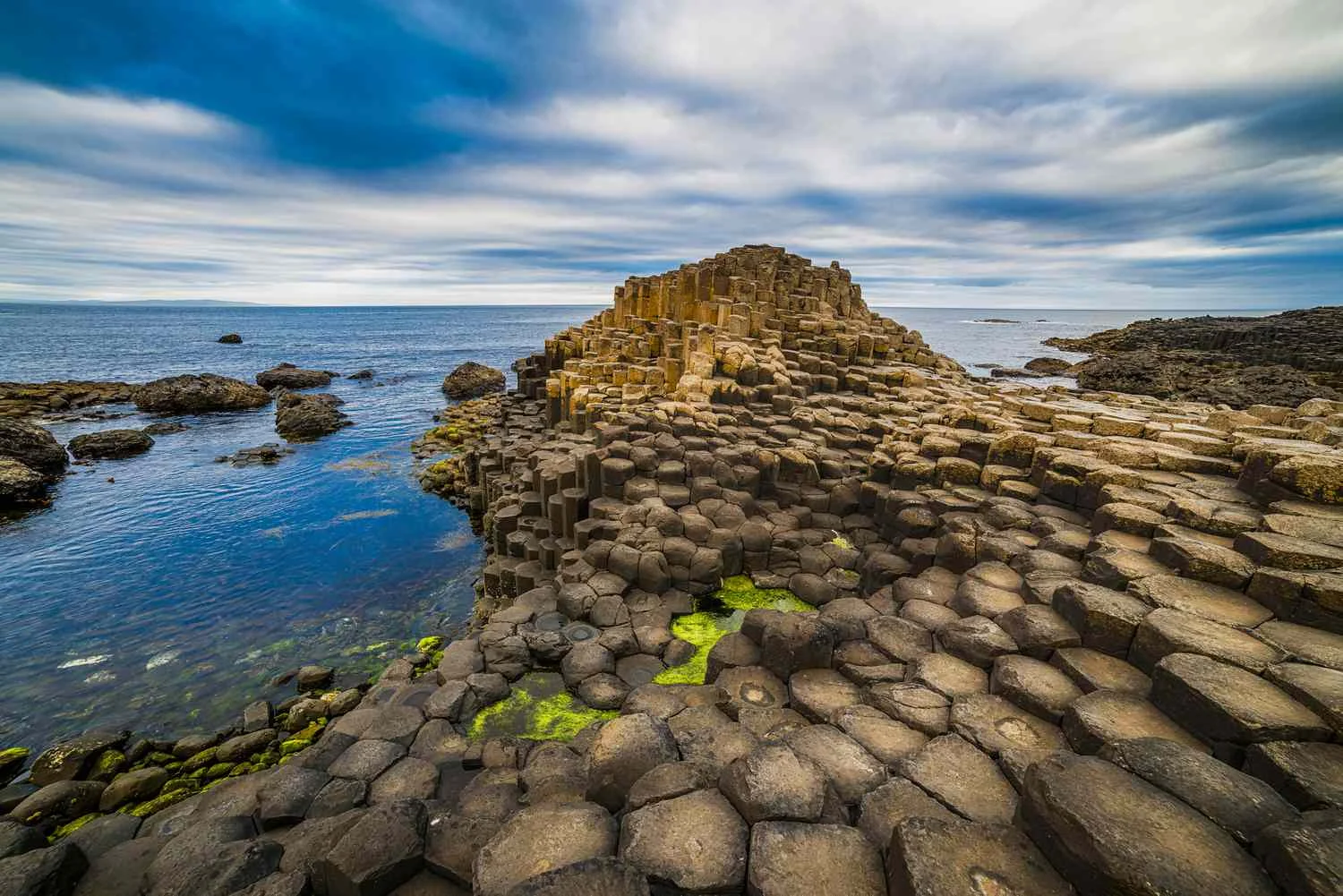 Close-up of the interlocking hexagonal basalt columns at the Giant's Causeway on the north coast of Northern Ireland under a dramatic sky.
