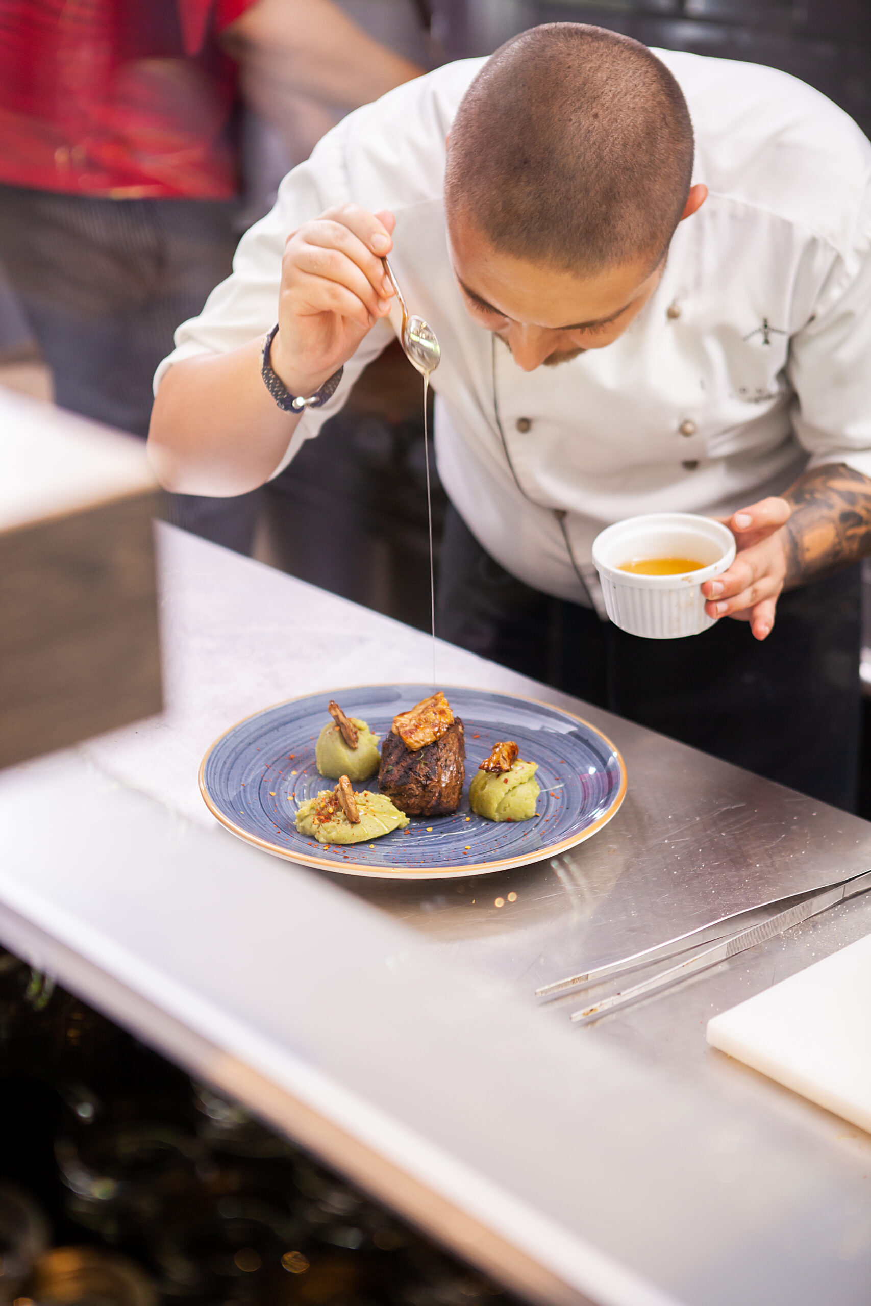 Chef carefully plating a dish in a Michelin-starred restaurant kitchen