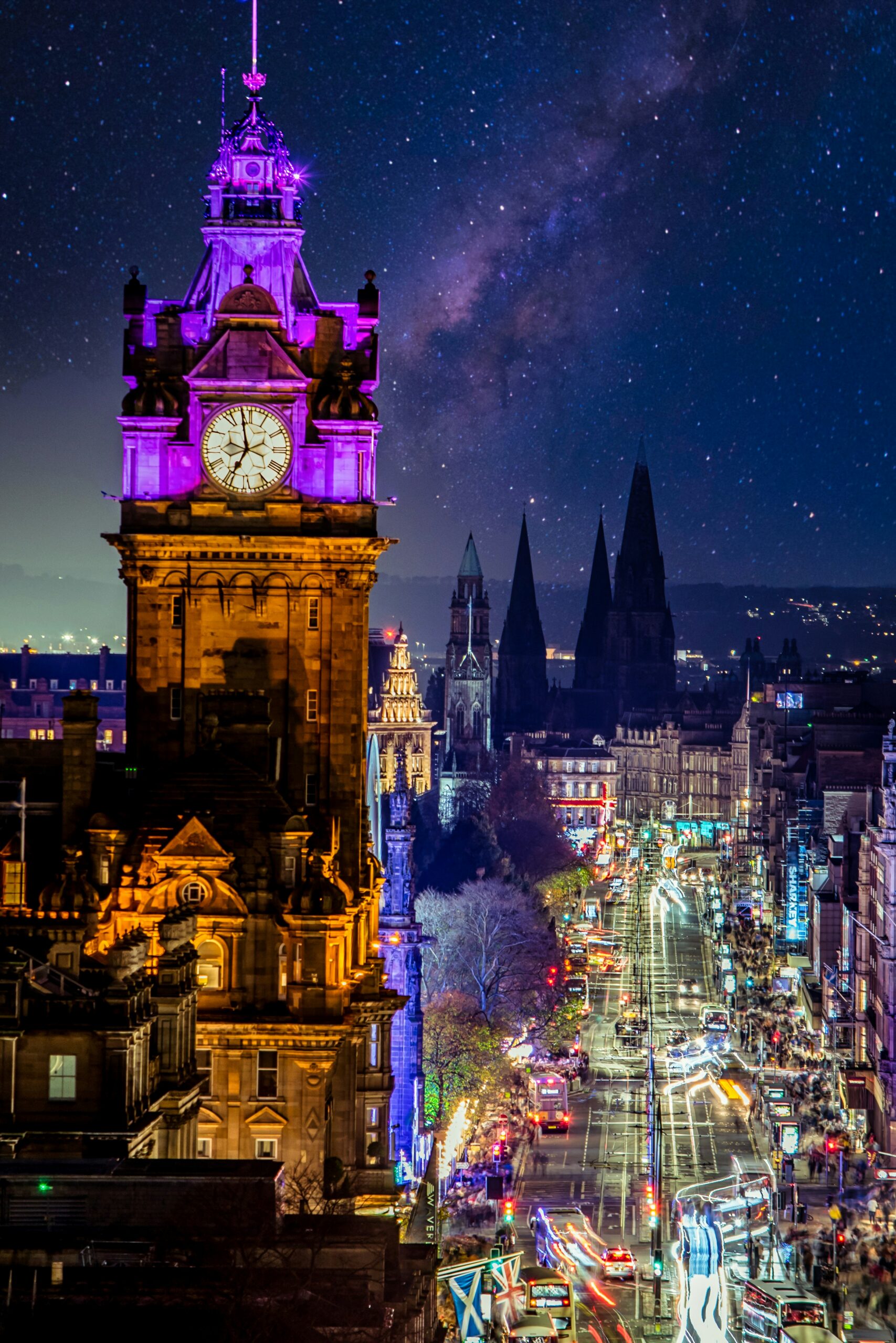 Edinburgh's illuminated clock tower and Christmas market lit up at night