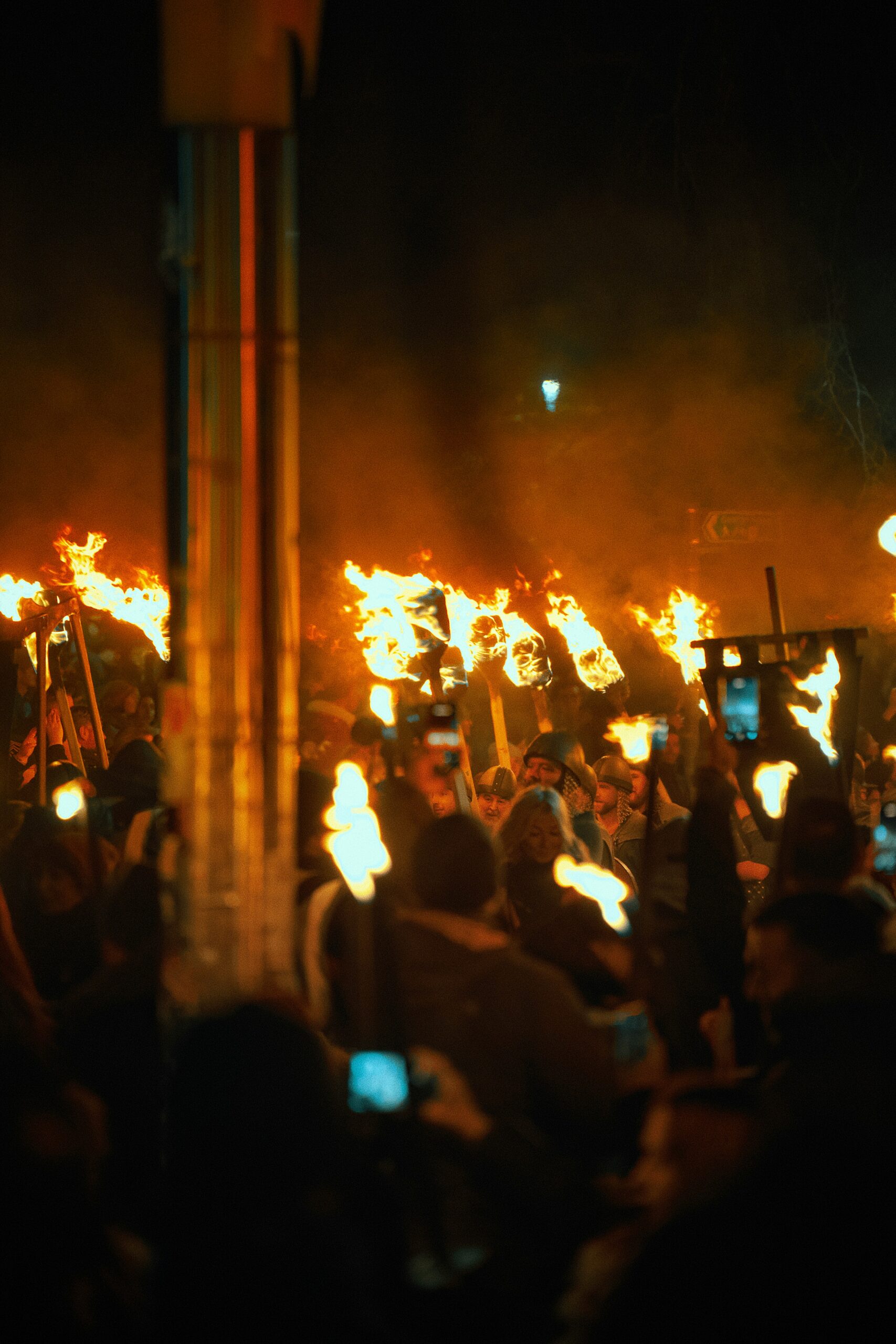 Crowd carrying flaming torches through the streets during Edinburgh's Hogmanay procession