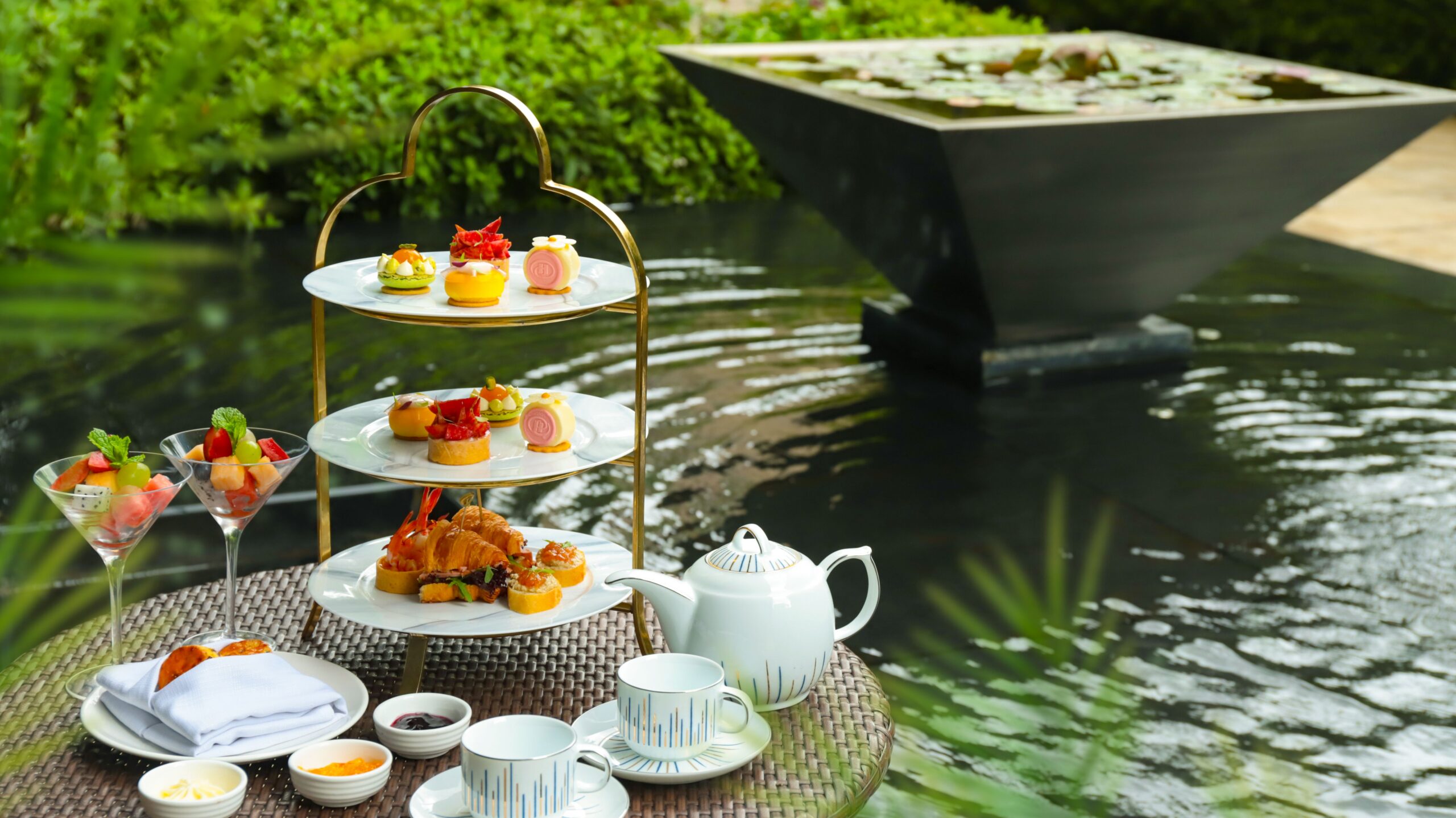 Traditional afternoon tea tiered stand served riverside on a boat deck