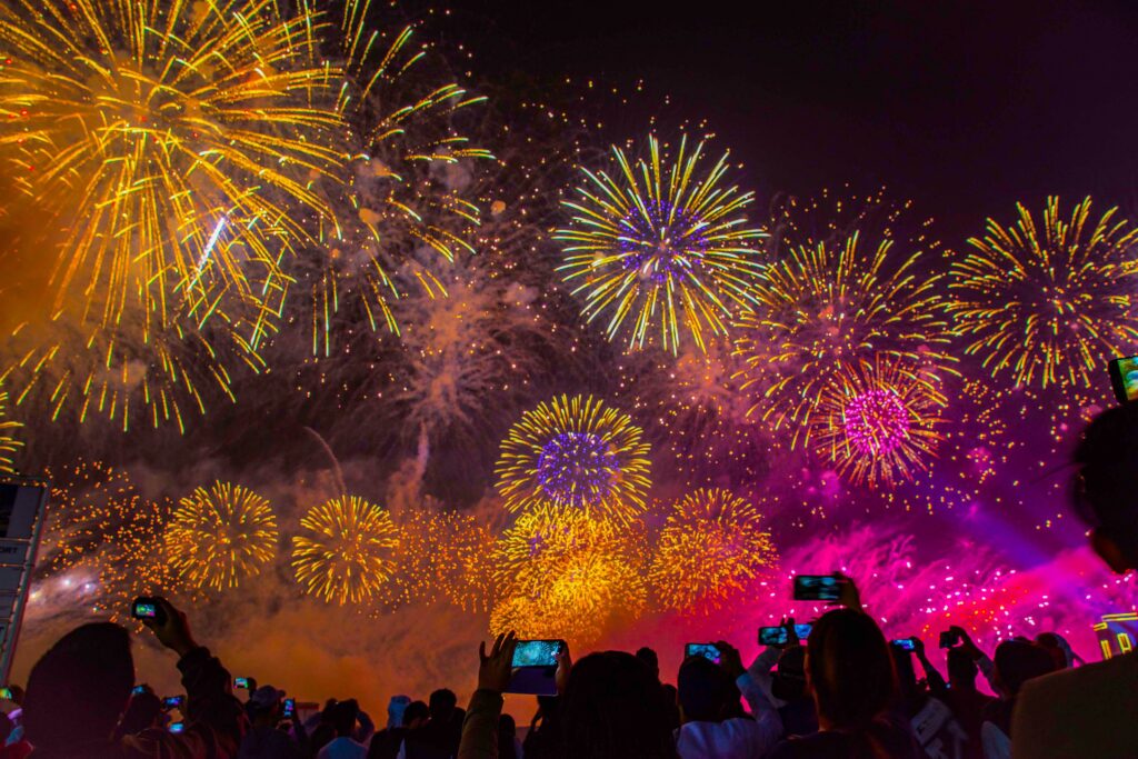 Fireworks lighting up Edinburgh Castle during the Hogmanay New Year celebration with crowds below