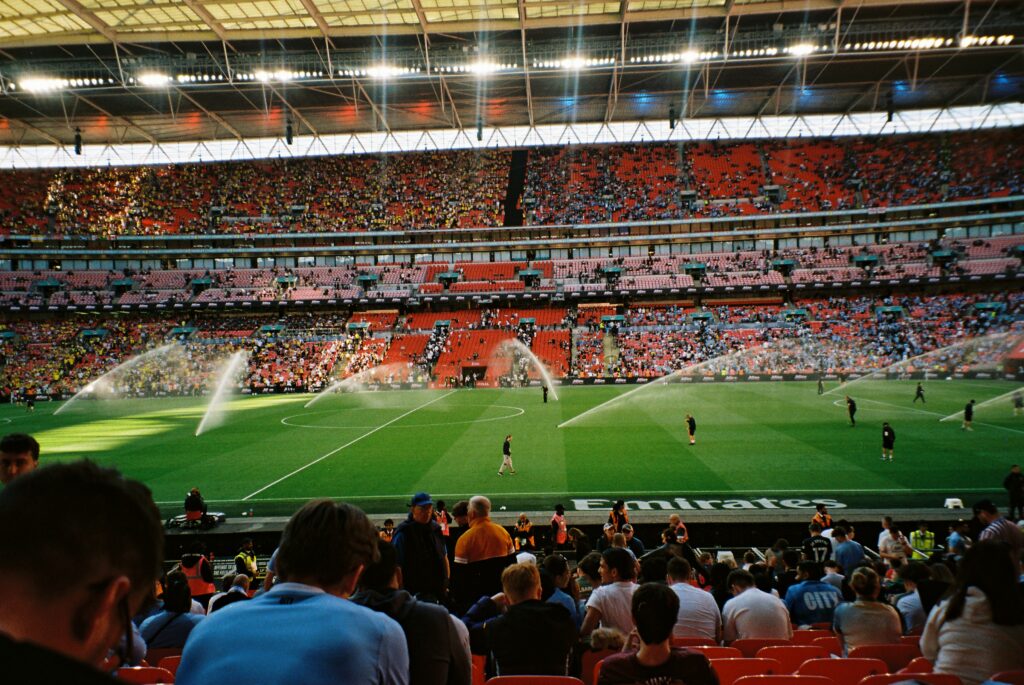 Packed crowd at Wembley Stadium during a live match under floodlights