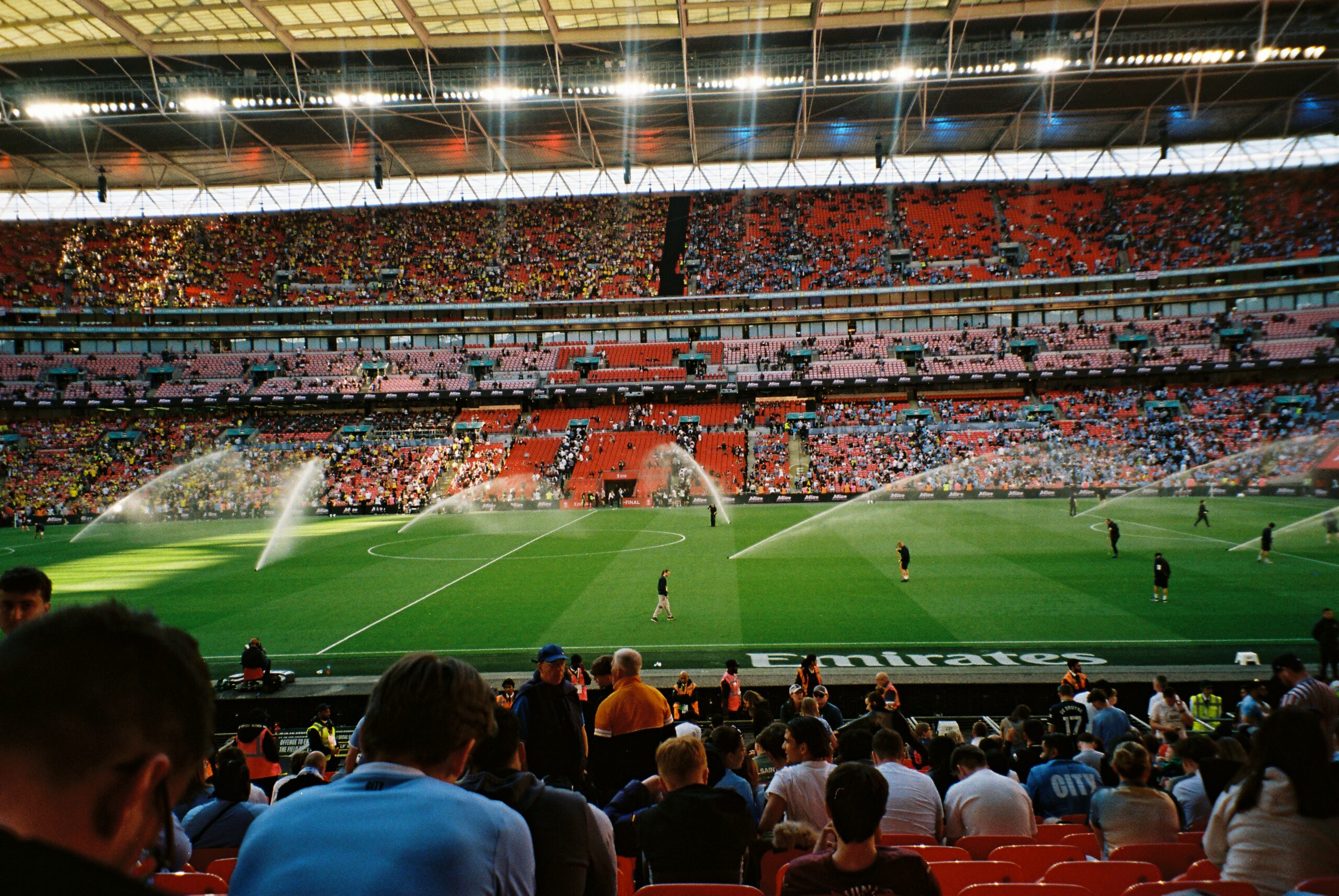 Packed crowd at Wembley Stadium during a live match under floodlights
