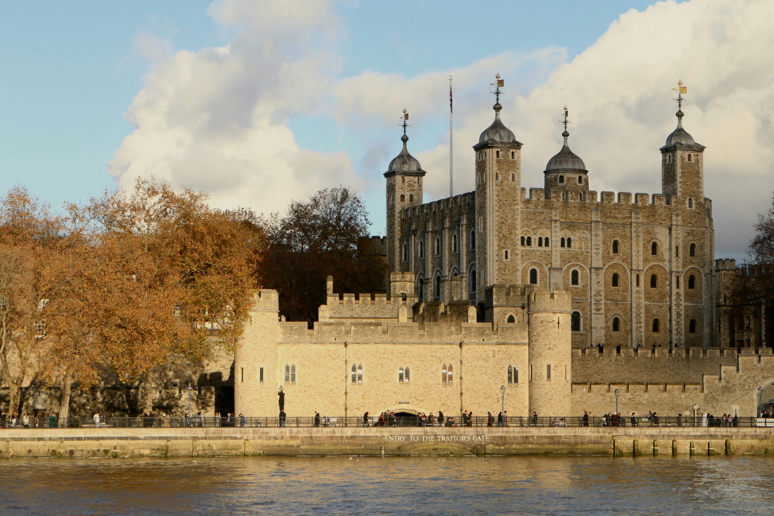 Tower of London's historic White Tower and turrets beside the River Thames